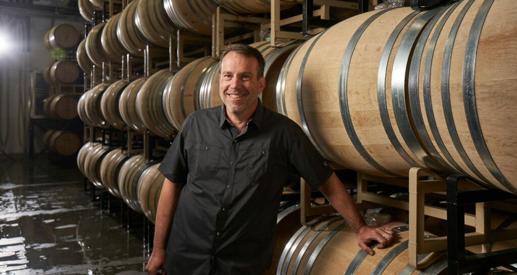 Brian Gruber descansa sobre una barrica en Irvine & Roberts Vineyards, en Ashland_Oregón. Crédito_Gregor Halenda.