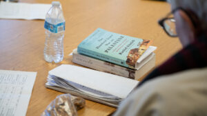 Notebooks, news articles and nonfiction books scatter the table at the political discussion group at the Port Angeles Senior and Community Center. (Credit: Tela Moss / NWPB)