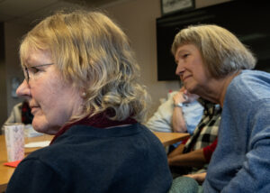 Pam Blakeman, left, and Kim Butler, right, listen during the discussion group on March 14. (Credit: Tela Moss / NWPB)