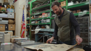 Historian David Brownell looks at archived newspapers in the North Olympic History Center on March 14. (Credit: Tela Moss / NWPB)