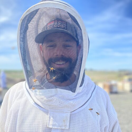 Brandon Hopkins, 42, with Washington State University, stands in front of the university’s bee colonies at a facility in Othello, Washington, where he and a team were examining the hives.